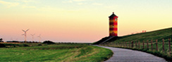 Landschaft mit Straße und Leuchtturm am Horizont